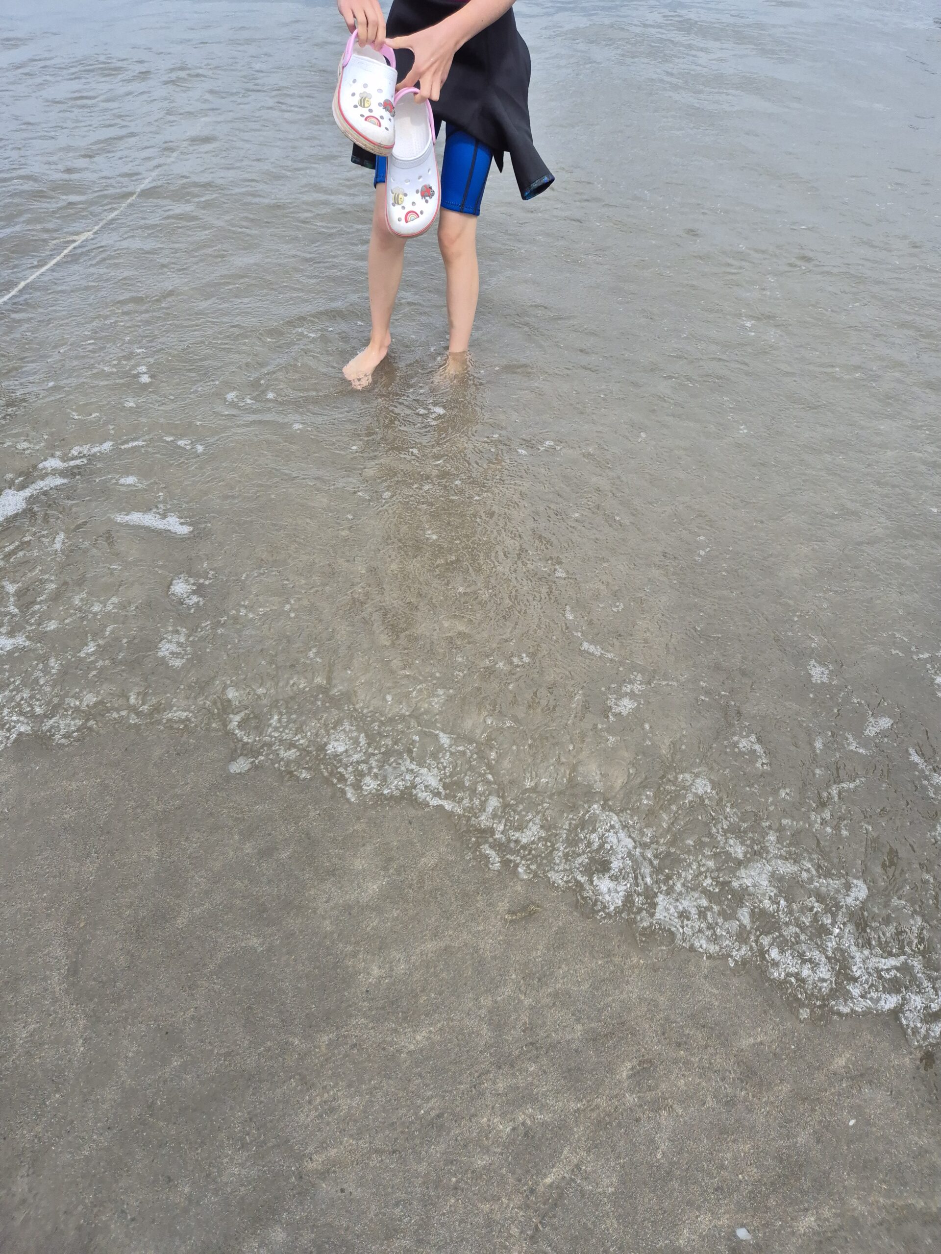 B's wet suited legs in the sea