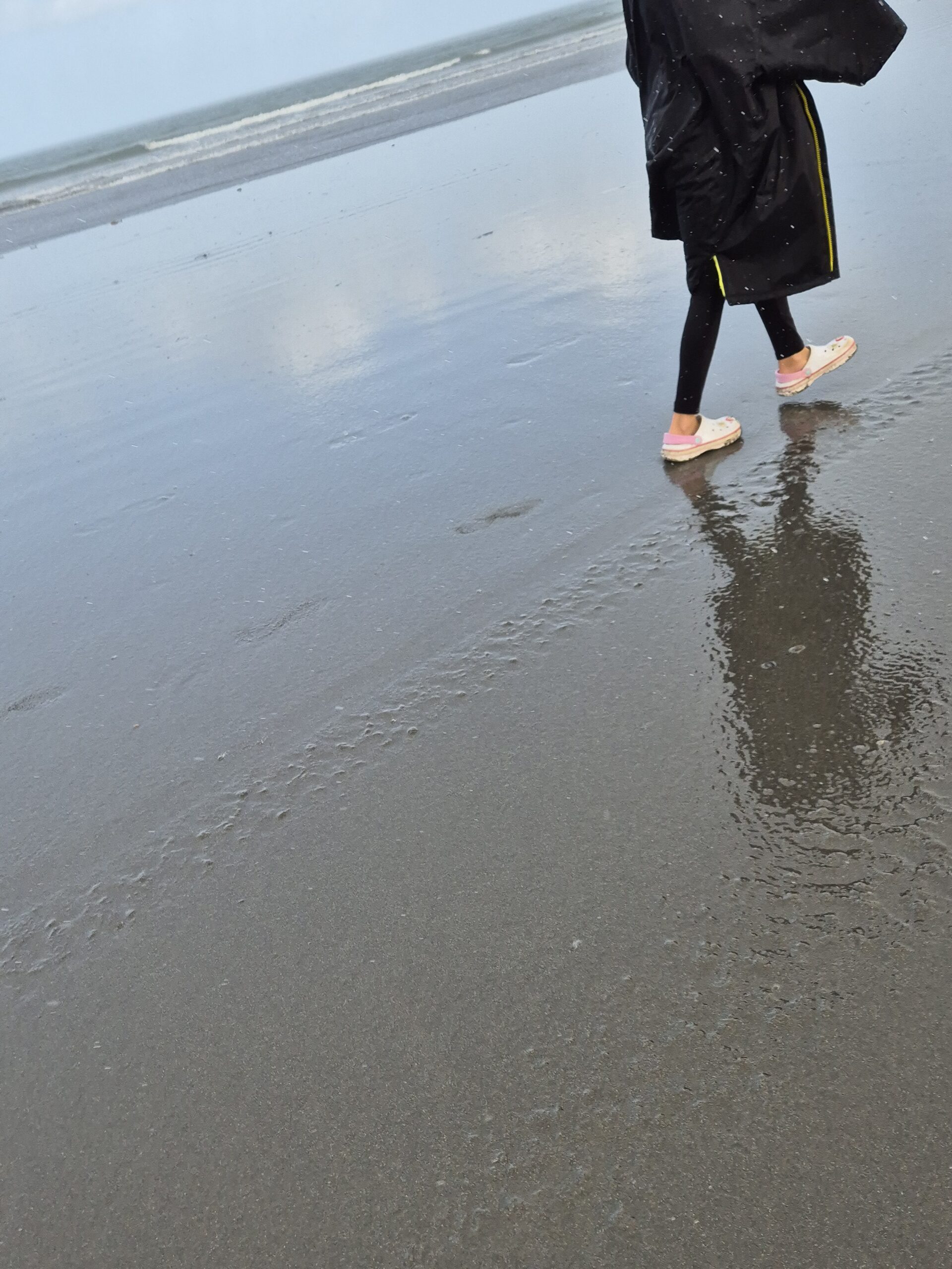 B's feet on wet sand