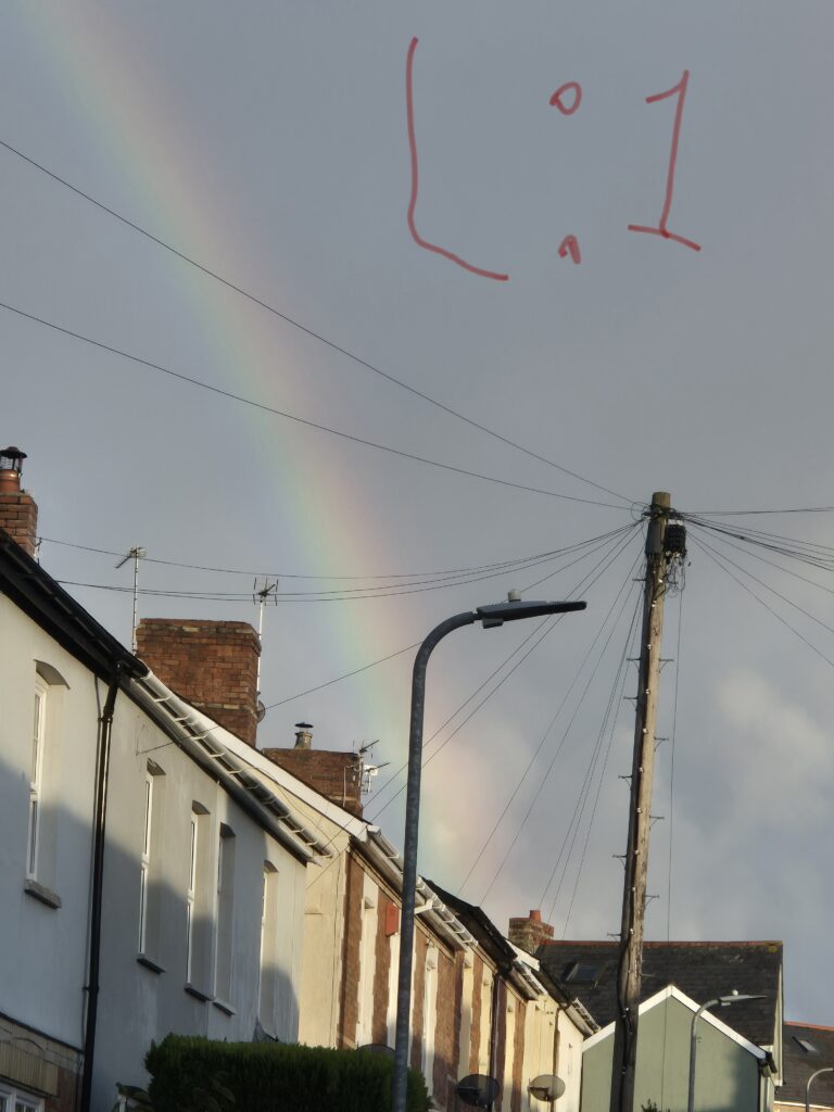 A rainbow behind a terraced street.
